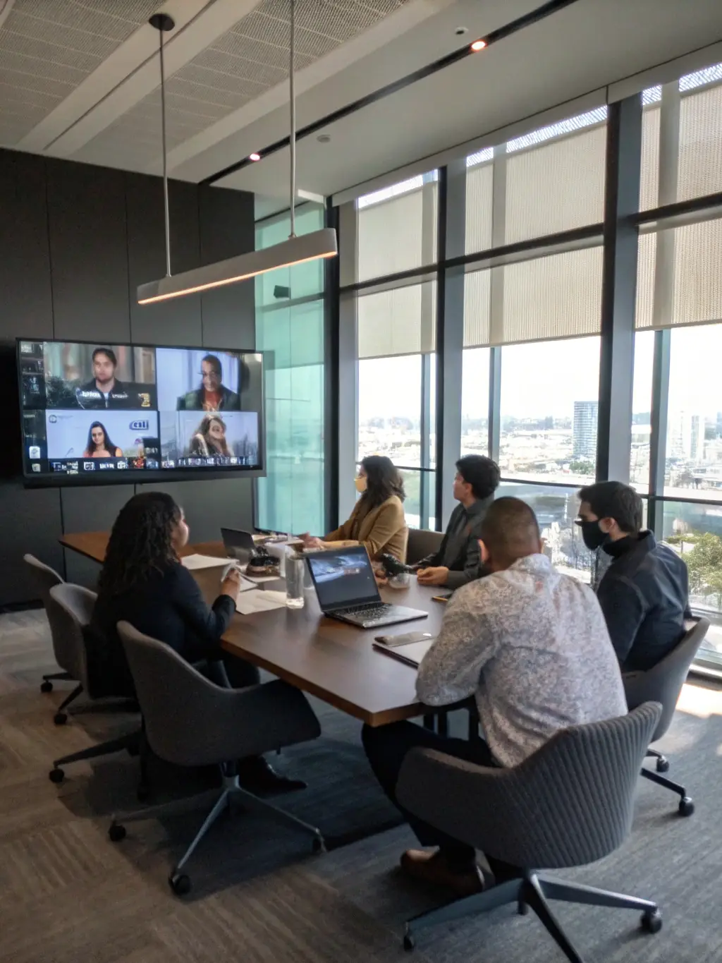 A group of professionals collaborating in a meeting room, connected via video conference, representing Viettelai's business solutions.